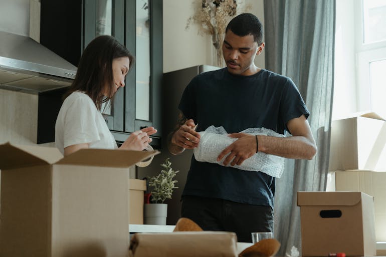 A couple using cushioning to protect their items after learning one of our packing tips to protect your valuables