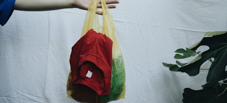 person holding a bag full of clothes