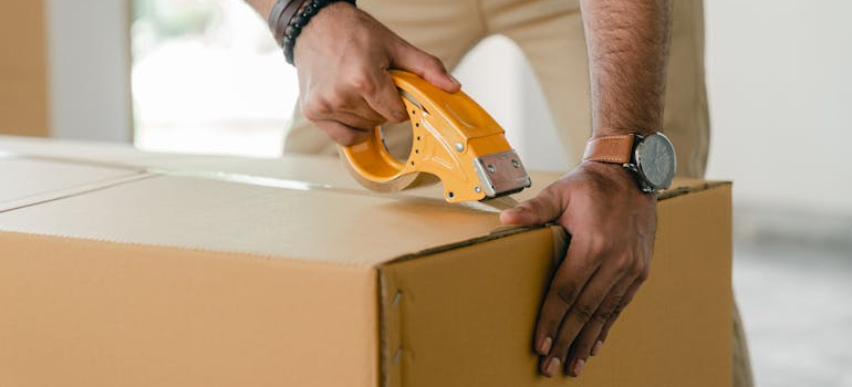person taping a box