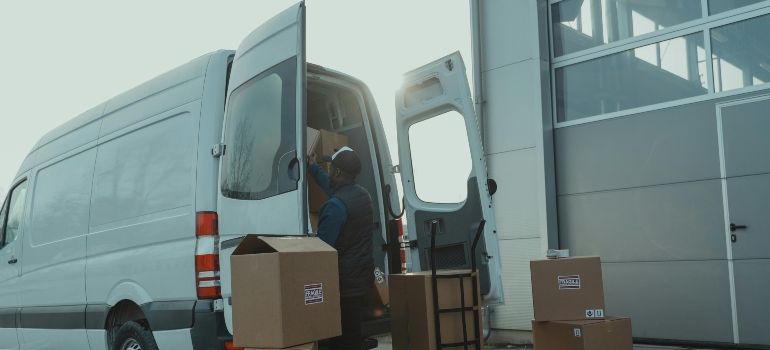 Movers Livonia MI carrying boxes next to a van