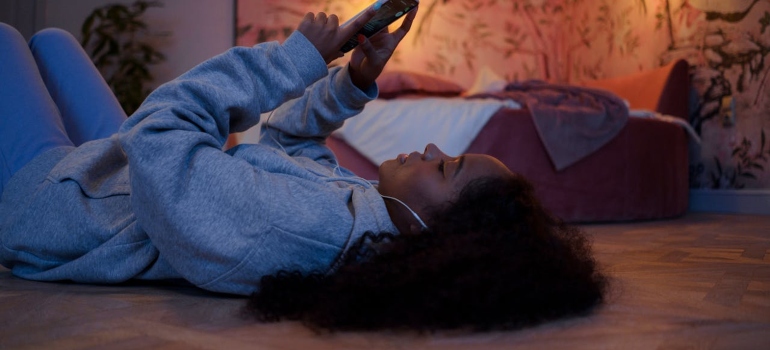 Teenager looking at their phone, they are also children who need support when moving.