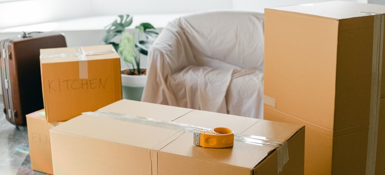 A cozy room with several cardboard boxes with labels