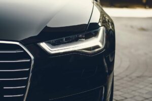 Close-up of a sleek black car's front, preparing from Shipping a car across the country