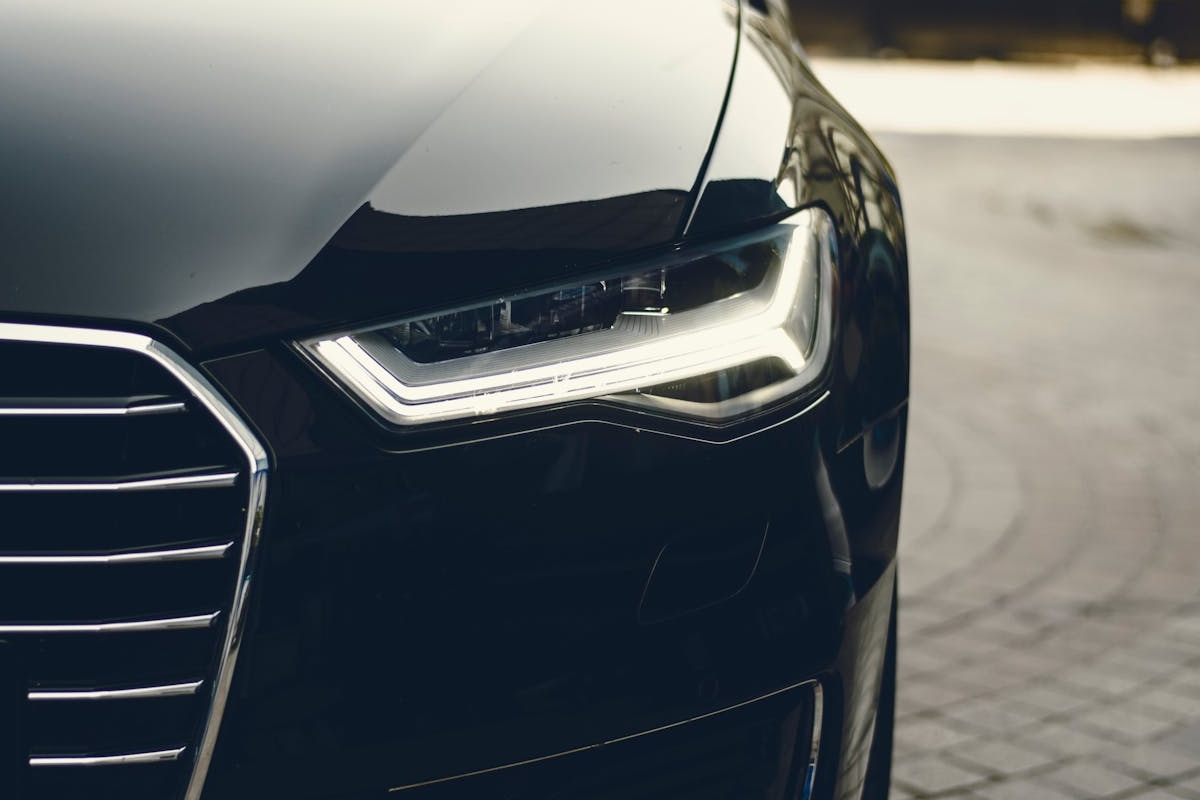 Close-up of a sleek black car's front, preparing from Shipping a car across the country