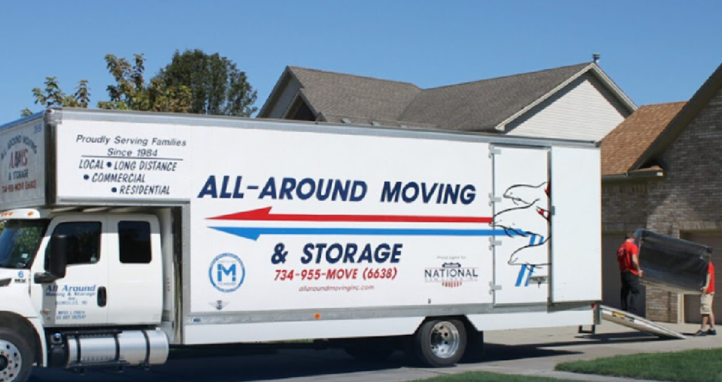 All Around Moving & Storage truck parked outside a suburban home, with movers in red shirts carrying furniture down a ramp on a clear day. The truck displays company branding, contact number, and website, highlighting professional residential relocation services.